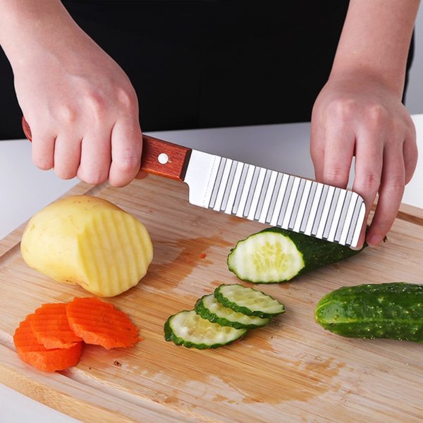 A woman holding a plate of food that is on a cutting board